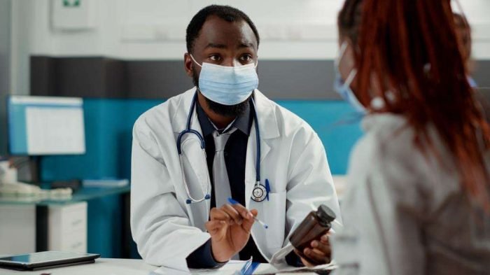 Maternity specialist and pregnant woman with face mask at checkup visit