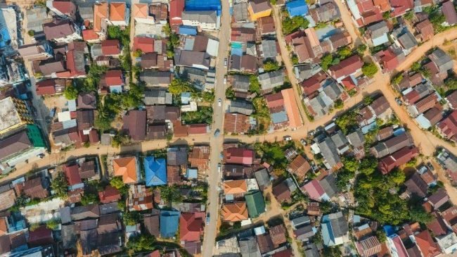 Aerial city view with crossroads and roads, houses, buildings, parks and parking lots, bridges. Copter shot. Panoramic image.